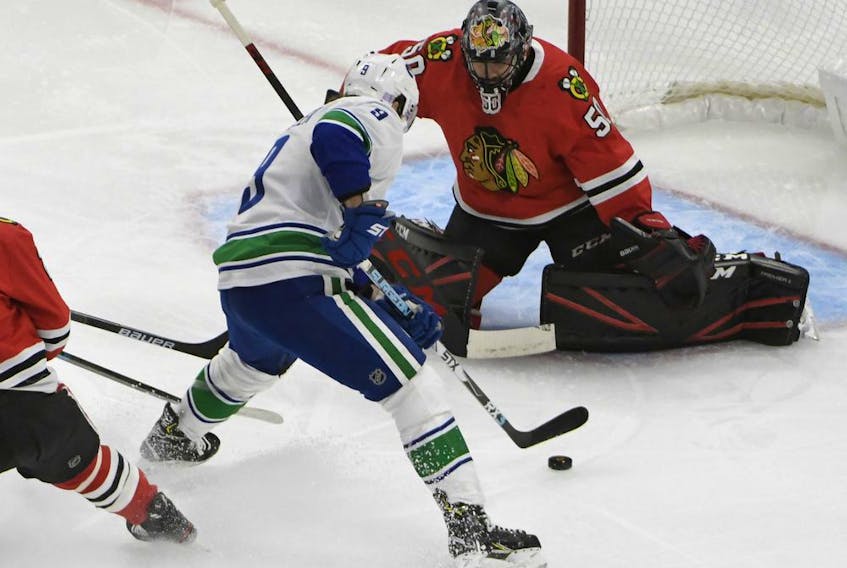 Vancouver Canucks center J.T. Miller (9) skates with the puck as Chicago Blackhawks goaltender Corey Crawford (50) defends during the first period at United Center.  
