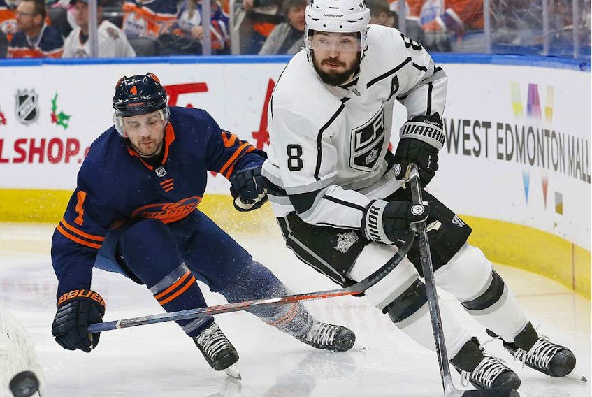  Kings defensemen Drew Doughty clears the puck in front of Edmonton Oilers defensemen Kris Russell during the second period at Rogers Place Friday, Dec. 6, 2019.