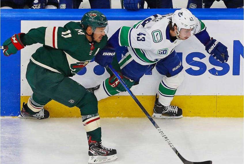 Minnesota Wild forward Zach Parise, left, and Vancouver Canucks defenceman Quinn Hughes chase a loose puck during the third period of Western Conference qualifying at Rogers Place on Aug. 6 in Edmonton.