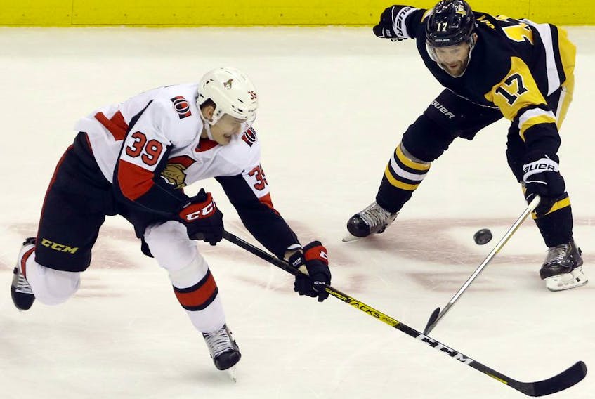 Ottawa Senators defenceman Andreas Englund and Pittsburgh Penguins right wing Bryan Rust each for the puck during the second period at PPG PAINTS Arena on March 3, 2020.