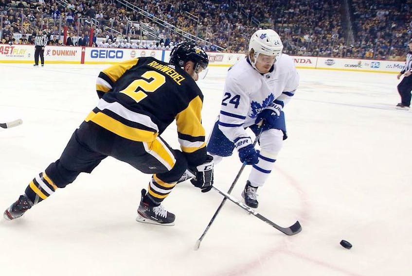 Pittsburgh Penguins defenseman Chad Ruhwedel and Toronto Maple Leafs right wing Kasperi Kapanen chase the puck during the first period at PPG PAINTS Arena. 