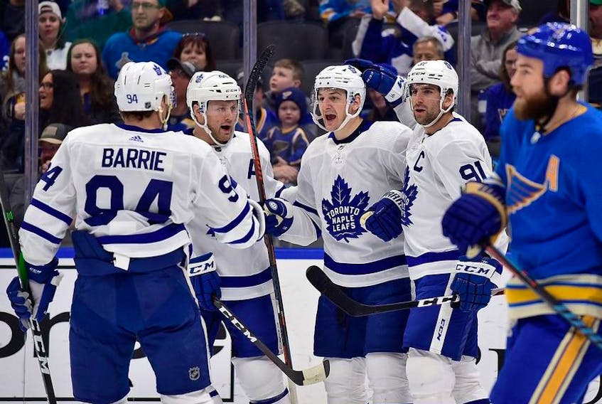 Toronto Maple Leafs left wing Zach Hyman  is congratulated by defenseman Morgan Rielly and defenseman Tyson Barrie and center John Tavares after scoring during the first period against the St. Louis Blues at Enterprise Center. 