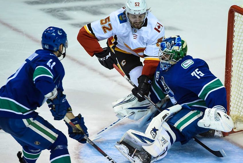  Vancouver Canucks goaltender Michael DiPietro (75) and forward Jonah Gadjovich (41) defend against Calgary Flames forward Justin Kirkland (52) during the second period at Save-On-Foods Memorial Centre.