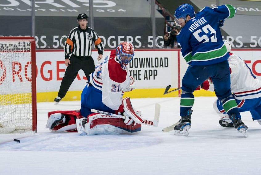 Canucks forward Bo Horvat and Canadiens goalie Carey Price track a rebound during third-period action Monday night at Rogers Arena in Vancouver. 