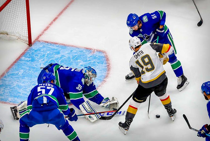 Canucks goalie Thatcher Demko makes a save on a shot by Vegas Golden Knights right wing Reilly Smith as Troy Stecher defends during the second period in Game 6.