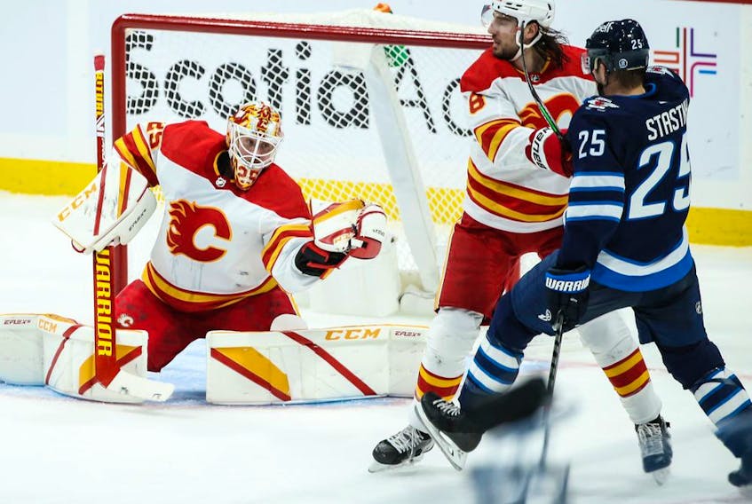 Calgary Flames goalie Jacob Markstrom (25) makes a save as defenceman Chris Tanev blocks out Winnipeg Jets forward Paul Stasny during the second period at Bell MTS Place in Winnipeg on Thursday, Jan. 14, 2021. 