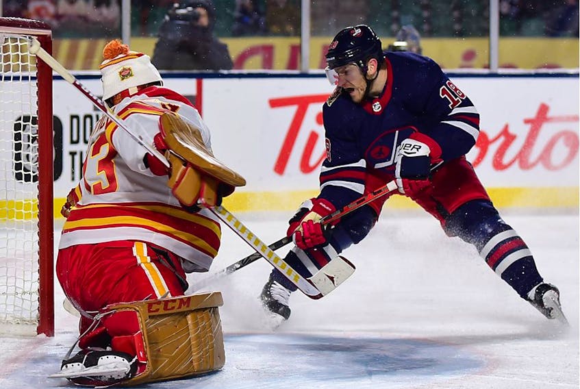 Winnipeg Jets forward Bryan Little (18) scores against Calgary Flames goaltender David Rittich (33) during overtime of the 2019 Heritage Classic outdoor hockey game at Mosaic Stadium in Regina on Saturday night.
