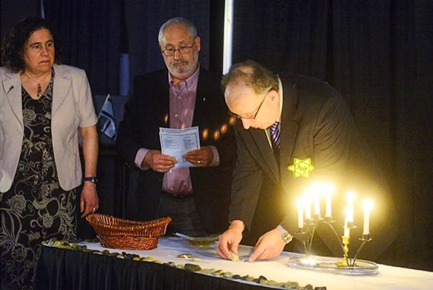 The annual Holocaust Memorial service was held Monday, April 28 in Charlottetown. Remembering the more than six million murdered Jews with six candles and one more candle for the estimated four to five million other murdered civilians during the Second World War are, from left, Rosalie Simeone, master of ceremonies, Leo Mednick of the Jewish Community of P.E.I. and Kim Dormaar. After lighting the candles they continued the commemoration by selecting notes from a wicker basket, each bearing the name, age and hometown of a victim, then placing it under a stone.