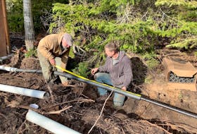 Steve and homeowner Brad installing an insulated and heated water line on a site with too little soil for frost protection. Brad says the fully encased, 150-foot-long installation has no noticeable effect on his electricity bill.