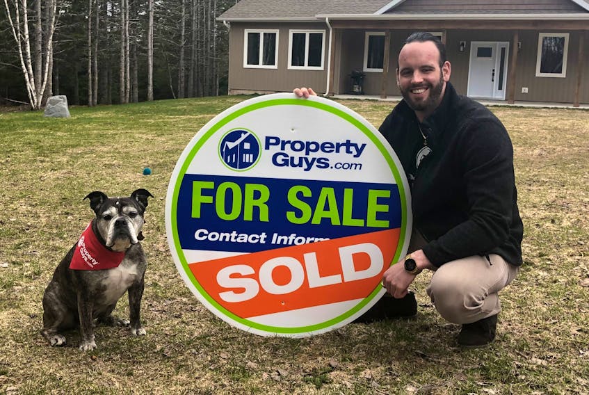Jesse Denton, a new Property Guys franchise owner, and his dog Diesel are shown outside of one the homes he has for sale on Mountain Road, Coxheath. Denton purchased the franchise in January. GREG MCNEIL/CAPE BRETON POST