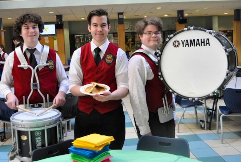 <p>Max Bobbitt, left, plays his snare drum, Jacob Hillier holds up fundraising pancakes and Aidan Levy-Fisk has the bass drum prepped for the new Horton High School drumline.</p>
