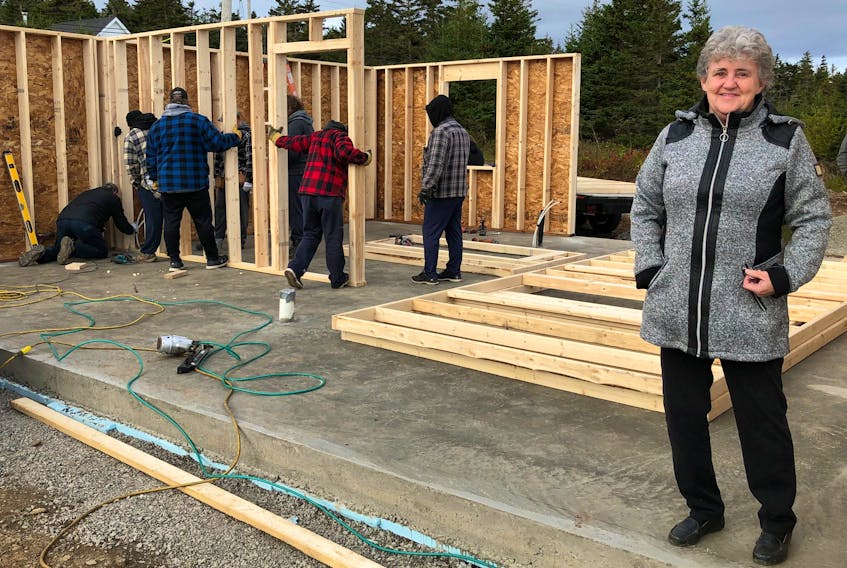Barbara Lahey stands inside what will be her new home as a group of volunteers work behind her constructing it. Thanks to the kindness of the community, the 69-year-old widower is being given the home. NICOLE SULLIVAN/CAPE BRETON POST 