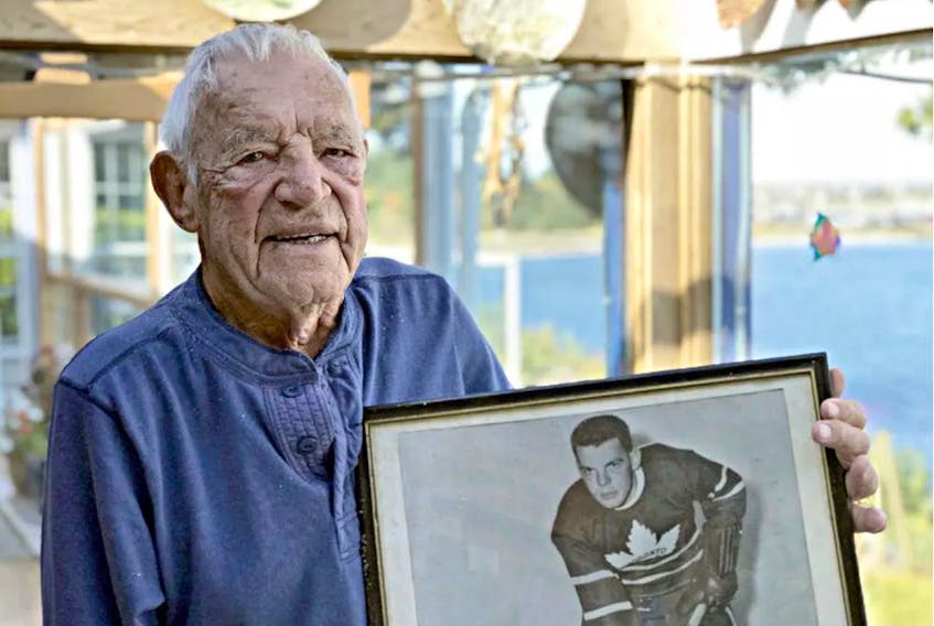 In this 2017 file photo, Howie Meeker hold s a picture of him as a rookie with The Toronto Maple Leafs in the 1946-47 season. — Contributed/Postmedia
