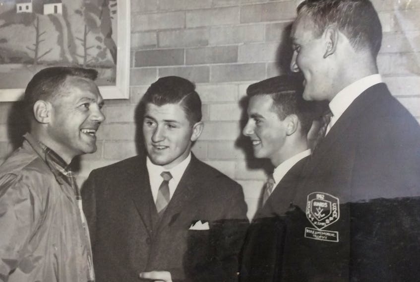 Howie Meeker (left) talks with members of the Guards senior hockey team — Hubert Hutton (second from left), Don Warr and Jack Drover (right), at the St. John's airport in 1962. — Contributed/Jack Drover
