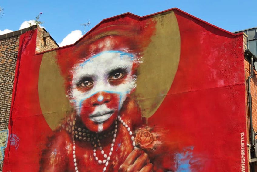 During the first Cities of Hope street art convention in 2016, Manchester artist Dale Grimshaw used his Globalization, 'Free West Papau' and '2 Worlds' themes to paint the side of a Spear Street building with the image of a young Papua New Guinea child wearing body paint and facing a harsh future. (Ian Robertson)