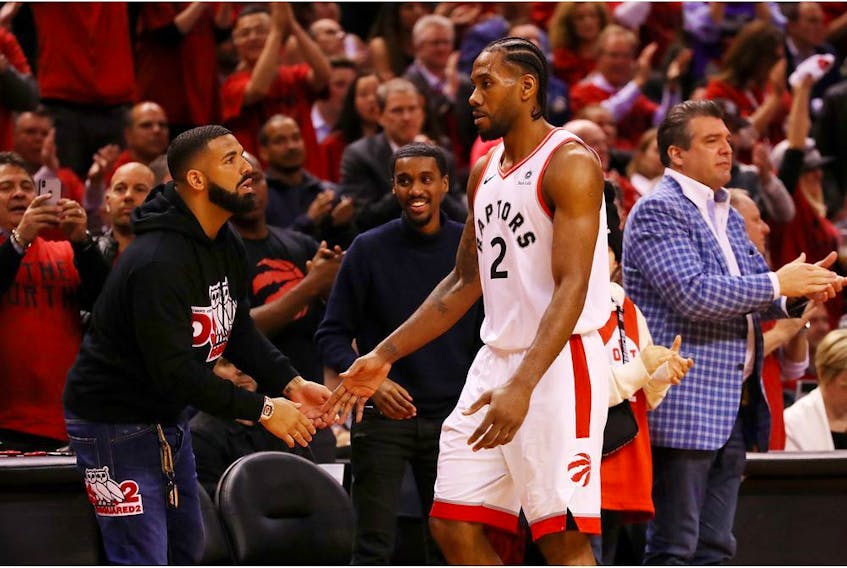 Kawhi Leonard #2 of the Toronto Raptors high fives rapper Drake during game four of the NBA Eastern Conference Finals between the Milwaukee Bucks and the Toronto Raptors at Scotiabank Arena on May 21, 2019 in Toronto, Canada. 