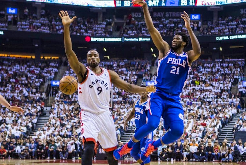 Raptors’ Serge Ibaka (left), sporting a bandage after getting an accidental Kawhi Leonard elbow to the head, defends against Sixers’ Joel Embiid during Game 5 on Tuesday.  
Ernest Doroszuk/Toronto Sun
