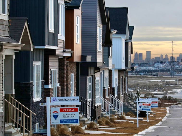 Attached homes for sale in the Livingstone community are framed again the distant Calgary skyline on Wednesday January 30, 2019. Gavin Young/Postmedia
