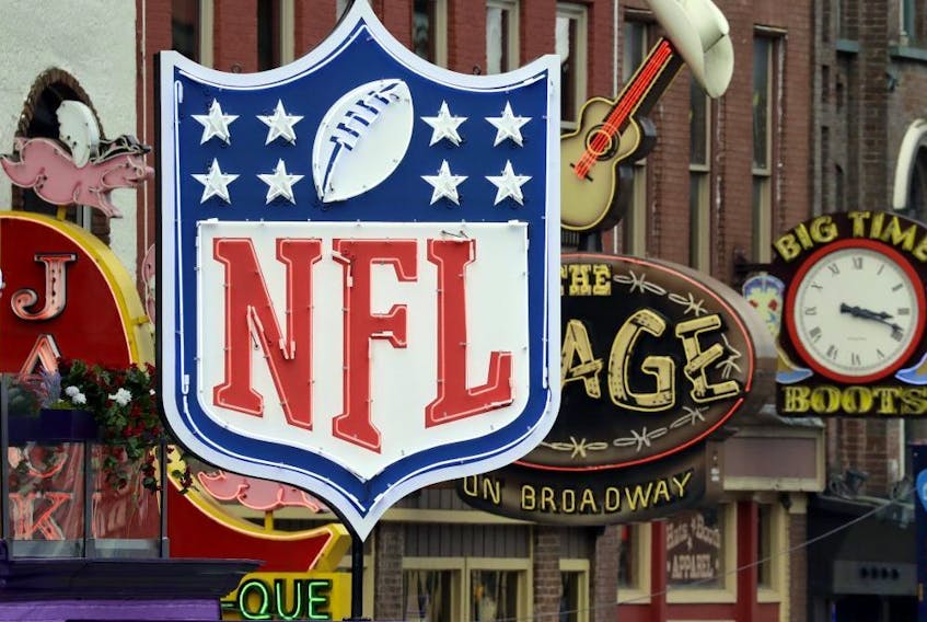 A temporary NFL neon sign joins the permanent ones along Broadway as preparation continues for the NFL Draft Tuesday, April 23, 2019, in Nashville, Tenn. The NFL Draft is scheduled to be held Thursday through Saturday.