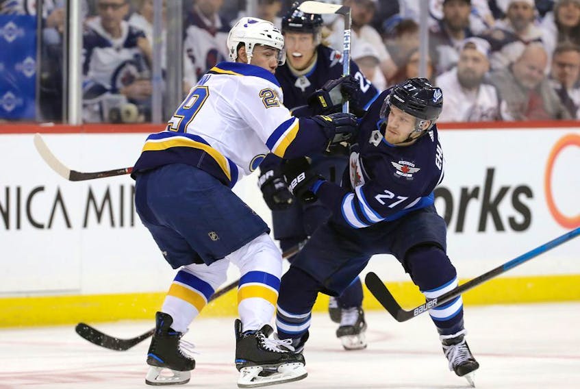 Vince Dunn of the St. Louis Blues battles Nikolaj Ehlers of the Winnipeg Jets (27) in Game 5 of the Western Conference First Round during the 2019 NHL Stanley Cup Playoffs at Bell MTS Place on Friday.