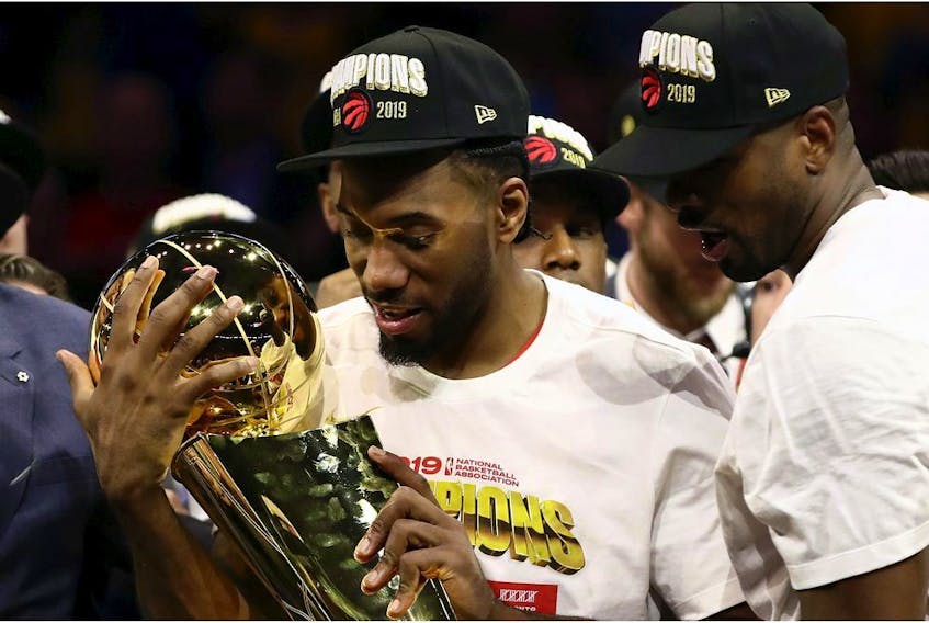 Kawhi Leonard #2 of the Toronto Raptors celebrates with the Larry O'Brien Championship Trophy after his team defeated the Golden State Warriors to win Game Six of the 2019 NBA Finals at ORACLE Arena on June 13, 2019 in Oakland, California. 