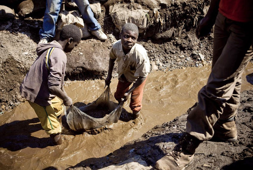 Children wash copper at an open-air mine in the mining province of Katanga, DRC. Children often drop out of school in order to earn some money from the mines.