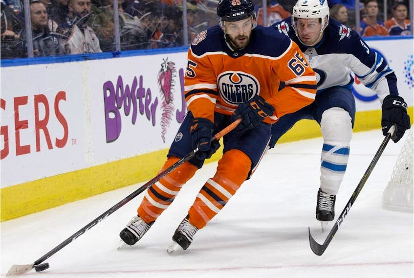 Edmonton Oilers forward Cooper Marody battles the Winnipeg Jets defenceman Tucker Poolman during pre-season NHL action at Rogers Place in Edmonton on Sept. 20, 2018. 