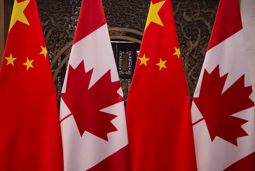 The Canadian and Chinese national flags hang side-by-side in this file photo.