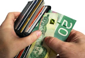 The action of pulling canadian money out of a wallet. ORG XMIT: POS1610071939292809