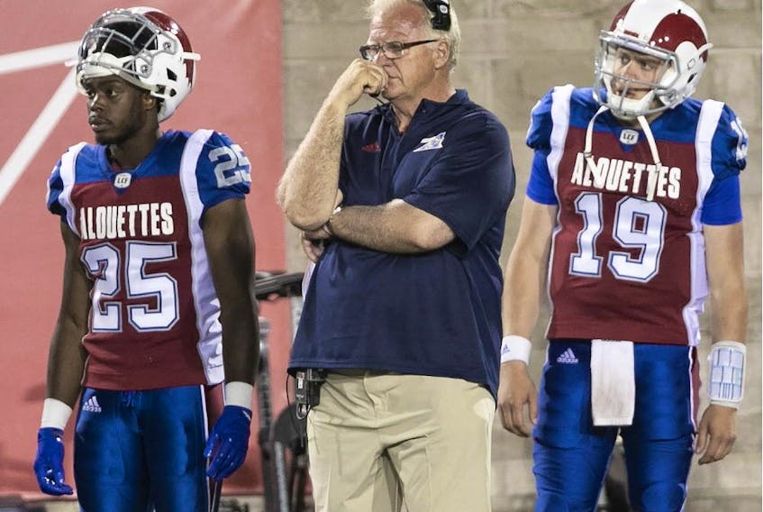 Alouettes head coach Mike Sherman on the sideline while standing between Dondre Wright (25) and Garrett Fugate as Montreal falls to the Winnipeg Blue Bombers 56-10 at Molson Stadium on June 22, 2018.