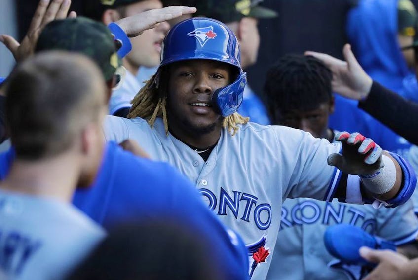 Toronto Blue Jays' Vladimir Guerrero Jr., celebrates with teammates after hitting a two-run home run during the eighth inning of a baseball game against the Chicago White Sox in Chicago, Sunday, May 19, 2019.