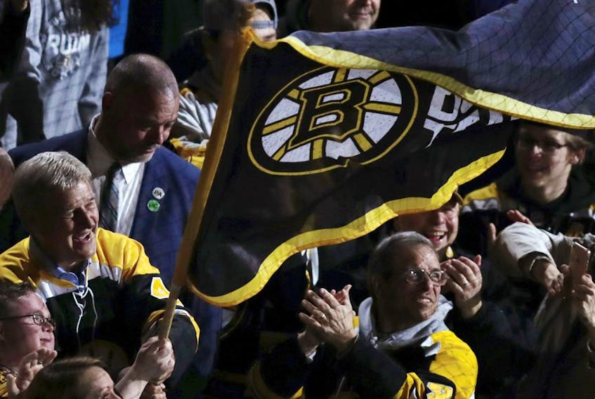 Boston Bruins great Bobby Orr, left, waves a team flag with fans prior to Game 2 of the Stanley Cup Eastern Conference final against the Carolina Hurricanes on Sunday, May 12, 2019, in Boston.