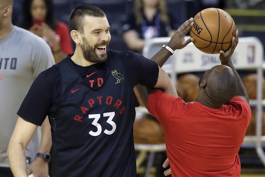 Raptors centre Marc Gasol (left) smiles next to a team assistant during a practice in Oakland yesterday.  The Associated Press