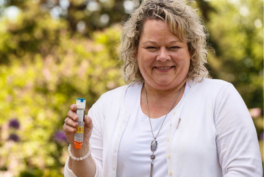 Fort Saskatchewan-Vegreville MLA Jackie Armstrong-Homeniuk holds an epinephrine autoinjector outside of the Alberta legislature in Edmonton on Thursday, June 13, 2019.