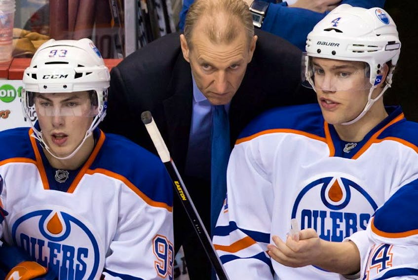 Edmonton Oilers' head coach Ralph Krueger, centre, talks to Taylor Hall, right, as Ryan Nugent-Hopkins, looks on during the third period of an NHL hockey game against the Vancouver Canucks in Vancouver, B.C., on Sunday January 20, 2013.