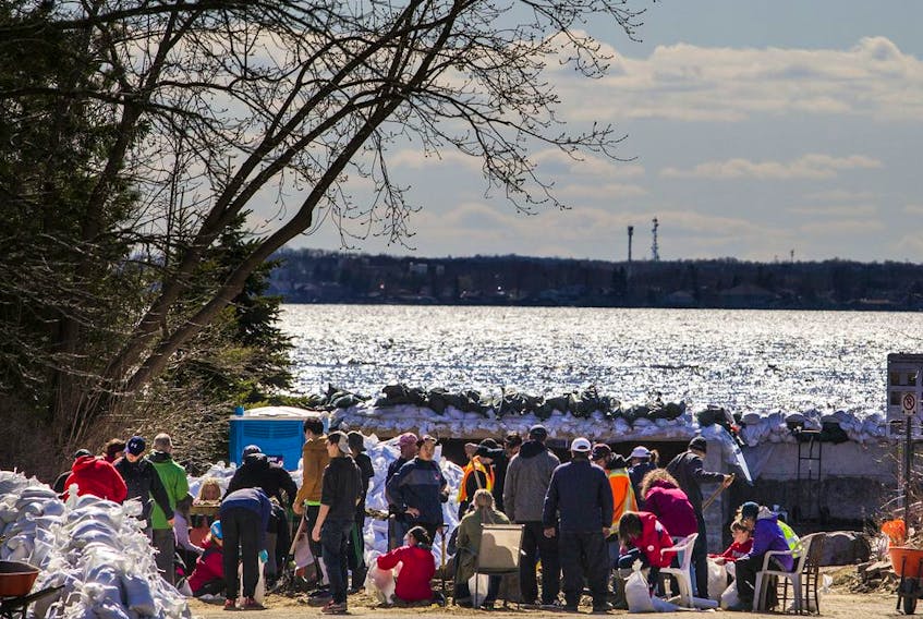  A berm on the Ottawa River near Jamieson Street holds back the flooding in the Britannia area as people gathered to build sandbags Sunday, April 28, 2019. Ashley Fraser/Postmedia