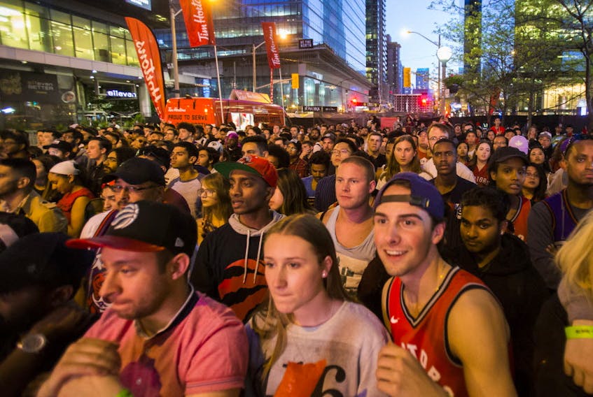 Logan Lindergaard (right) and Talia Manne watch Toronto Raptors during NBA Finals Game 4 against the Golden State Warriors held outside of the Scotiabank Arena at Jurassic Park in Toronto, Ont., on Friday, June 7, 2019. (Ernest Doroszuk/Toronto Sun/Postmedia)