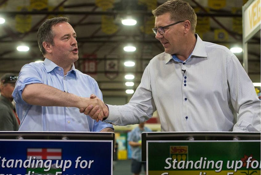 Saskatchewan Premier Scott Moe, right, shaking hands with Alberta Premier Jason Kenney, will be a speaker at a huge energy rally in Calgary Tuesday.