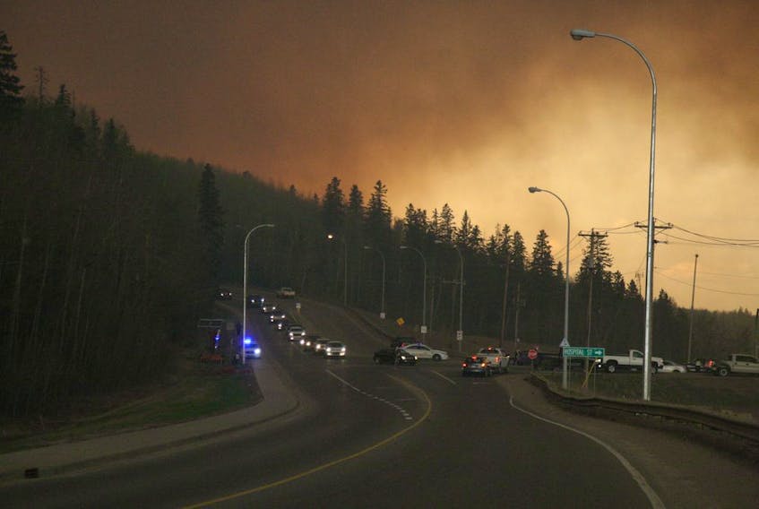 Residents of the subdivision of Abasand wait in their cars to leave the subdivision in Fort McMurray on May 3, 2016. The subdivision had been placed under a mandatory evacuation  with wildfires threatening the region. 