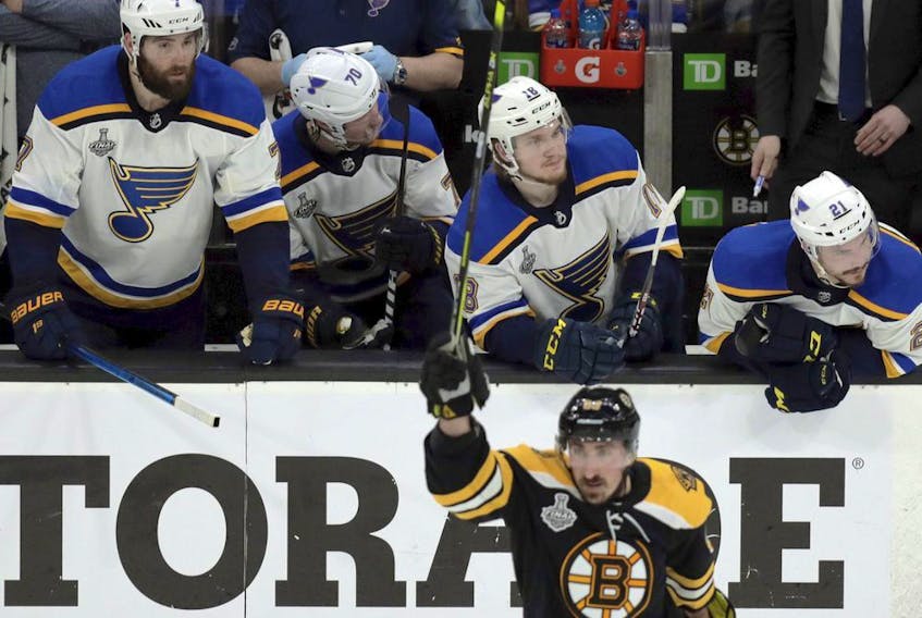 Blues players on the bench watch as the Bruins' Brad Marchand celebrates his empty-net goal during the third period in Game 1 on Monday night.