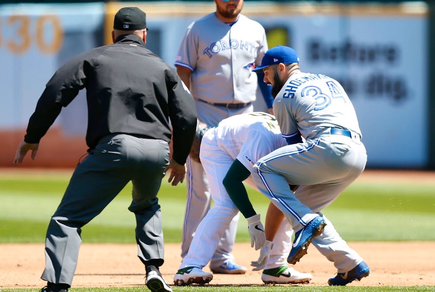 Jays pitcher Matt Shoemaker collides with As Matt Chapman on Saturday in Oakland. An MRI on Sunday revealed Shoemaker had torn his ACL and is done for the season.(Photo by Lachlan Cunningham/Getty Images)