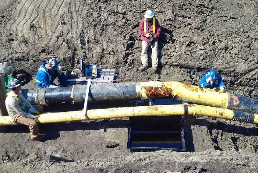 Workers examine the site of the 2016 Husky Energy Inc. pipeline spill into the North Saskatchewan River. The 16-inch pipe fractured due to an "active episodic landslide" on the riverbank.