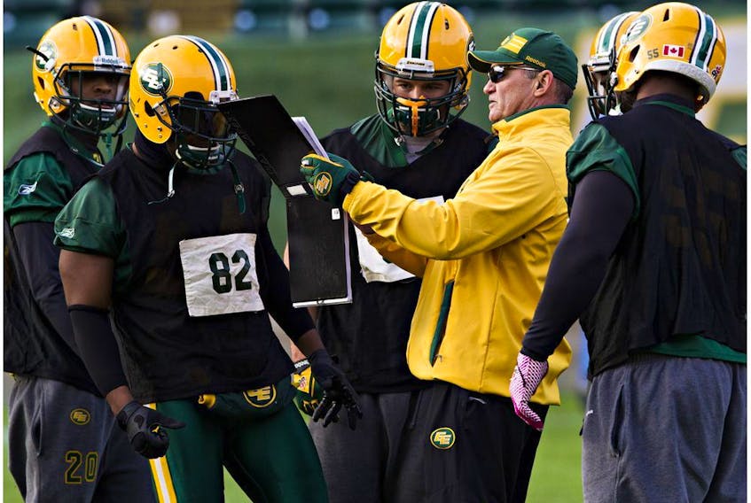 Linebackers coach Phillip Lolley runs plays during Edmonton Eskimos practice at Commonwealth Stadium in this file photo from Nov. 21, 2014. This season, he is back to co-ordinate the Eskimos defence.
