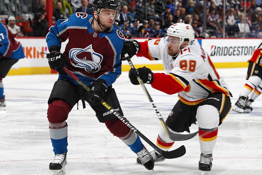Calgary Flames left wing Andrew Mangiapane, right, checks Colorado Avalanche right wing Sven Andrighetto after Andrighetto had passed the puck during the second period of Game 4 of an NHL hockey playoff series Wednesday, April 17, 2019, in Denver. (AP Photo/David Zalubowski) ORG XMIT: CODZ125