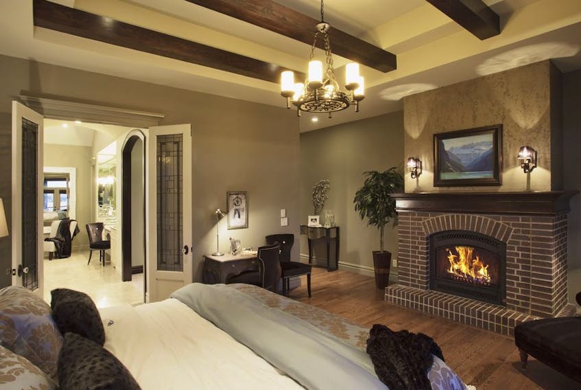 The ceiling details add ambience to a bedroom in a home by Wolf Custom Homes.