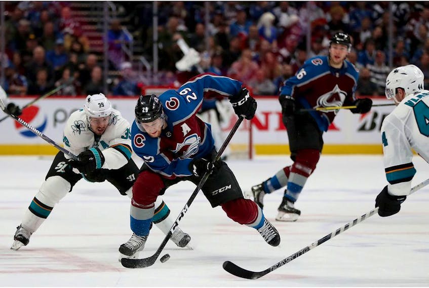 Nathan MacKinnon of the Colorado Avalanche advances the puck against Logan Couture of the San Jose Sharks in the second period during Game 4 of the Western Conference Second Round during the 2019 NHL Stanley Cup Playoffs at the Pepsi Center on May 2, 2019 in Denver, Colo.