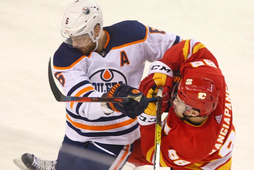 Oilers Adam Larsson battles with Flames Andrew Mangiapane at the Saddledome on Jan. 11, 2020. 
