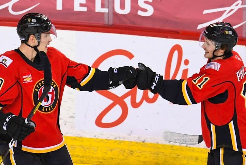 Stockton Heat centre Adam Ruzicka, left, celebrates with linemate Matthew Phillips. They have combined for 15 points in the first five games of 2021. (Courtesy of Stockton Heat)