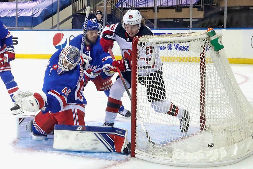 Jack Hughes of the New Jersey Devils scores his second goal of the second period against Alexandar Georgiev of the New York Rangers on Tuesday.