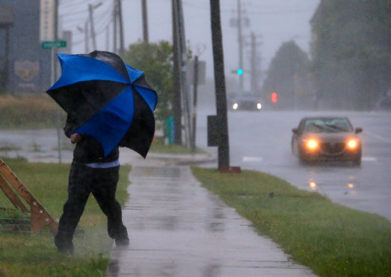 A man gets blown off the sidewalk beneath his umbrella, while walking along Wyse Road during an approaching Hurricane Dorian, in Dartmouth Saturday September 7, 2019.

TIM KROCHAK/ The Chronicle Herald